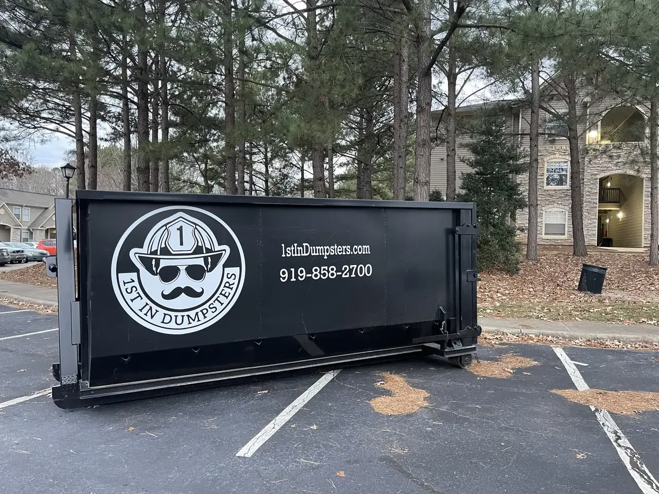 1st In Dumpsters roll off dumpster in an apartment complex parking lot